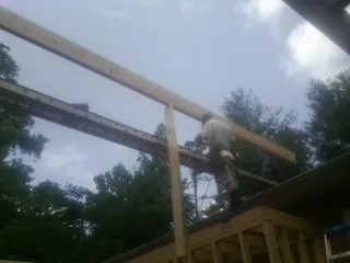 Carpenter setting a ridge beam over a new addition frame — Ice Dam Removal by Roofing Brothers in Caldwell
